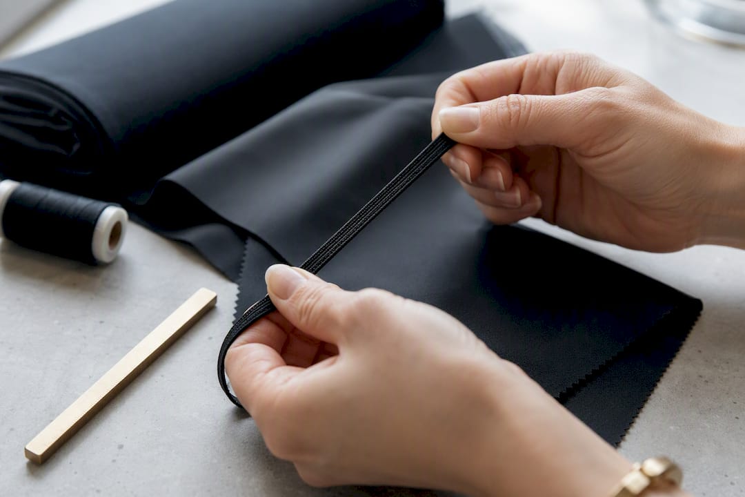 Hands testing elastic fabric recovery