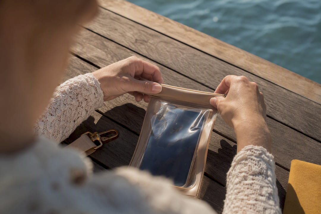 Hands sealing a waterproof phone pouch