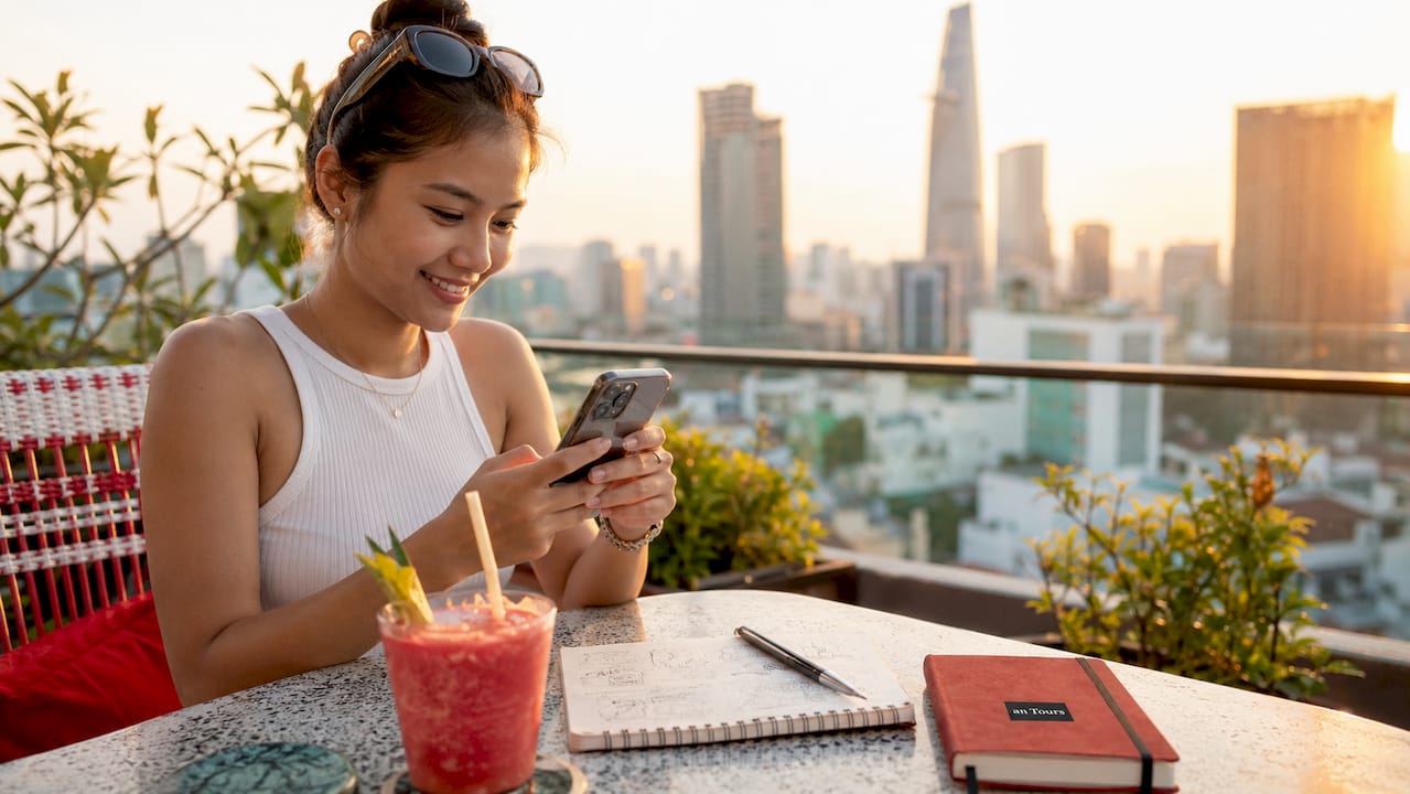 Person using smartphone at café engaging with community groups