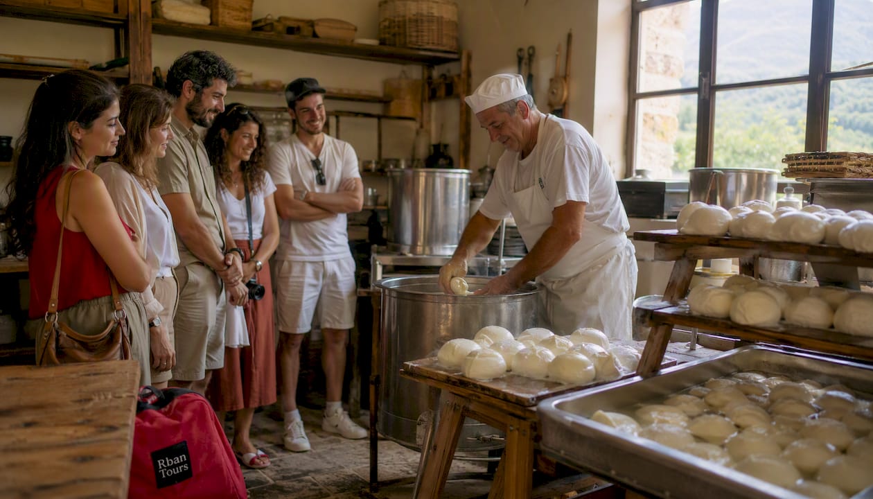 Tourists watching mozzarella cheese making process on farm