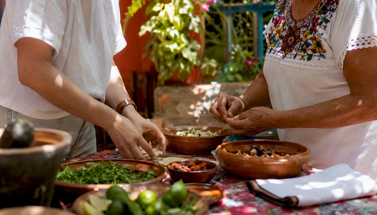Traveler and local sharing meal at kitchen table