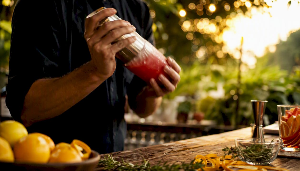 Hands pouring cocktail at bar