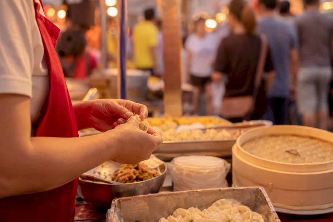 Hands preparing traditional food at market