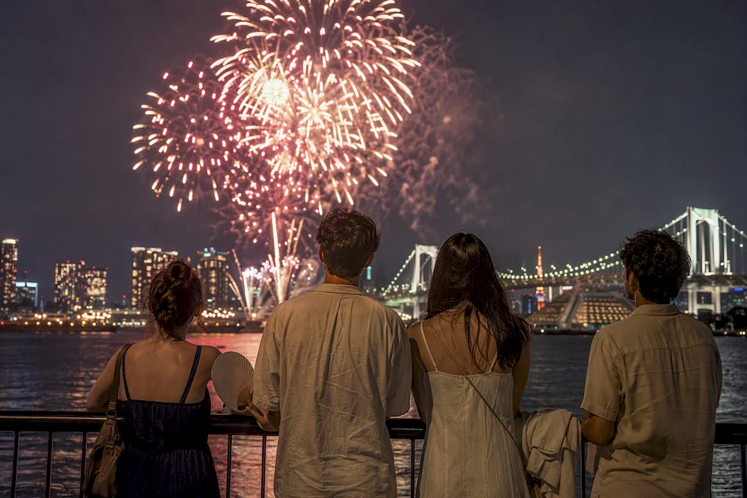 Tokyo Bay fireworks over evening skyline