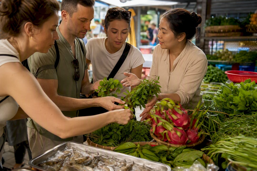 Travelers choosing herbs at a Vietnamese market