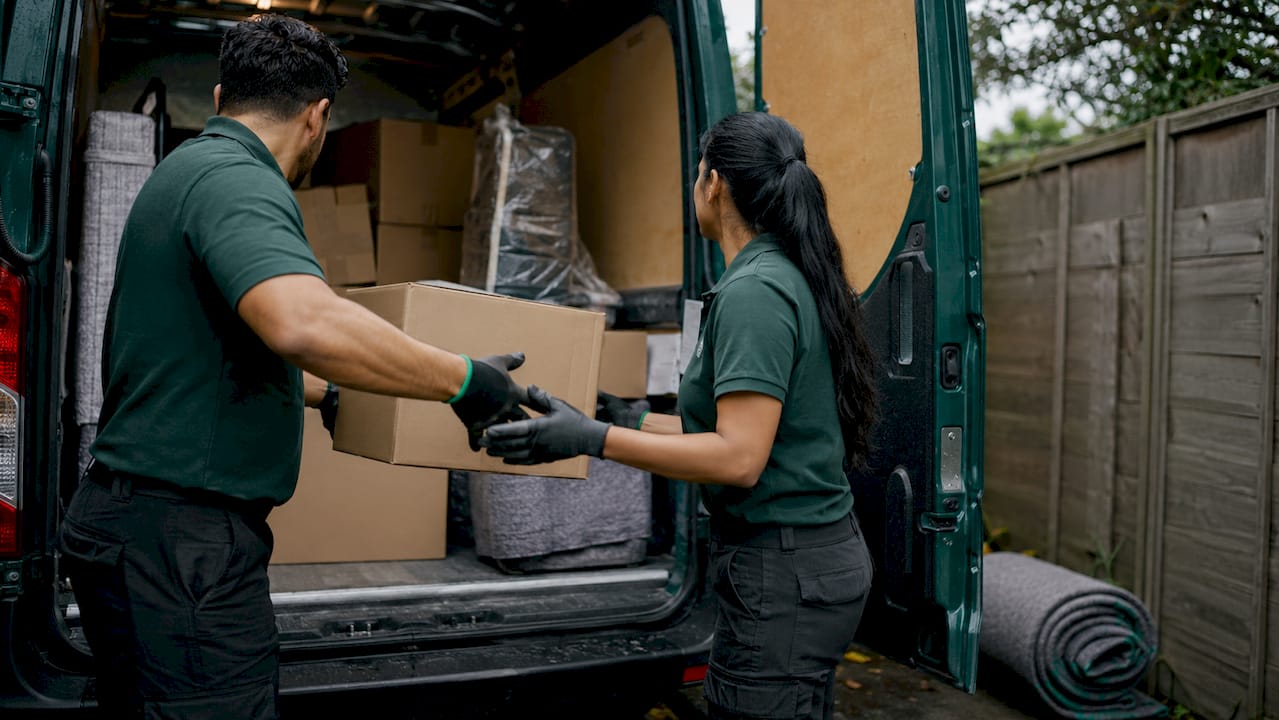 Movers loading storage boxes into van