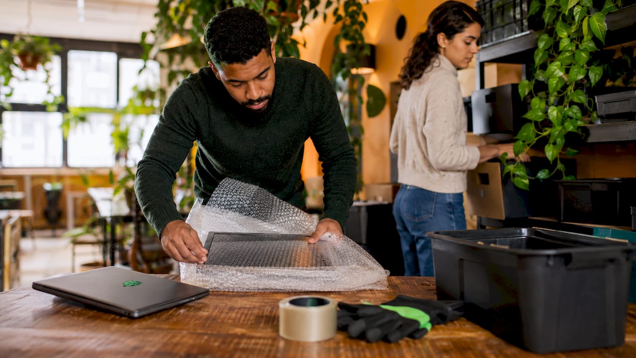 Workers packing IT equipment for office relocation