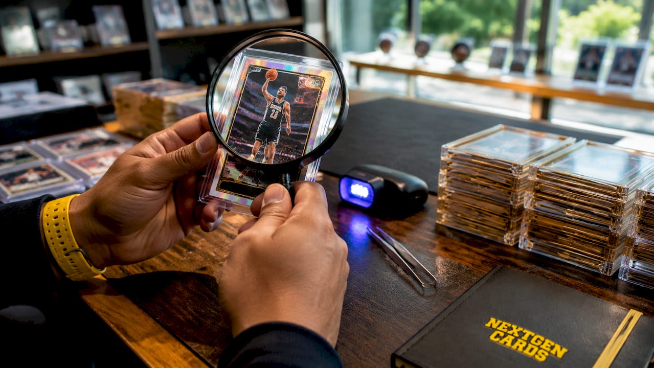 Close-up inspecting rookie card authenticity with magnifier