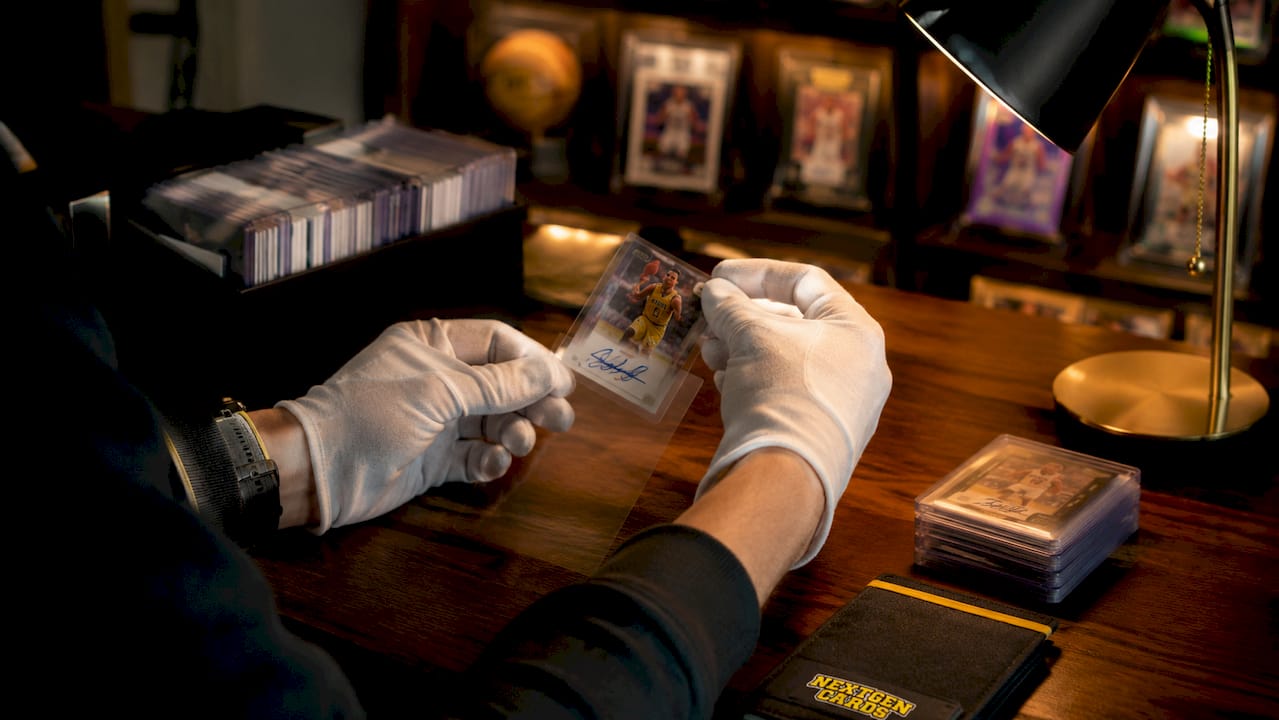 Gloved hands placing autographed card into sleeve