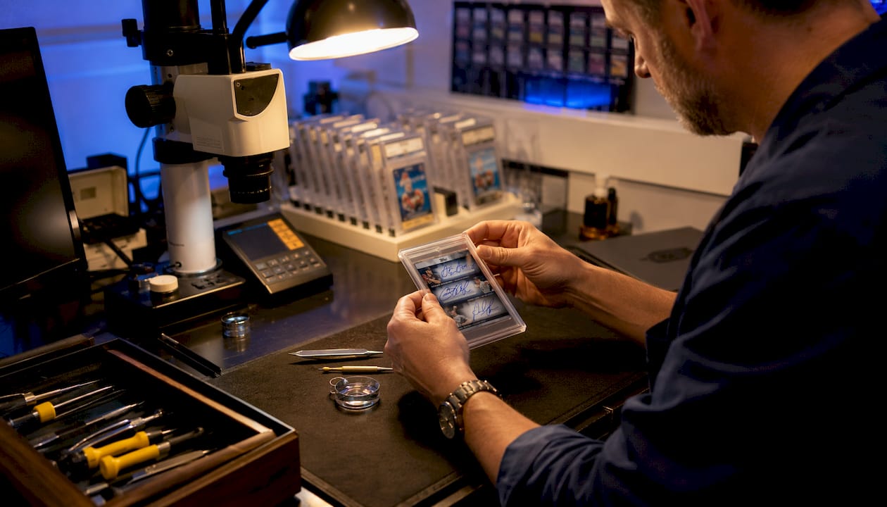 Grader inspecting sealed graded sports card
