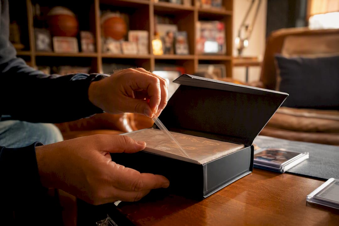 Hands unsealing premium autograph card box