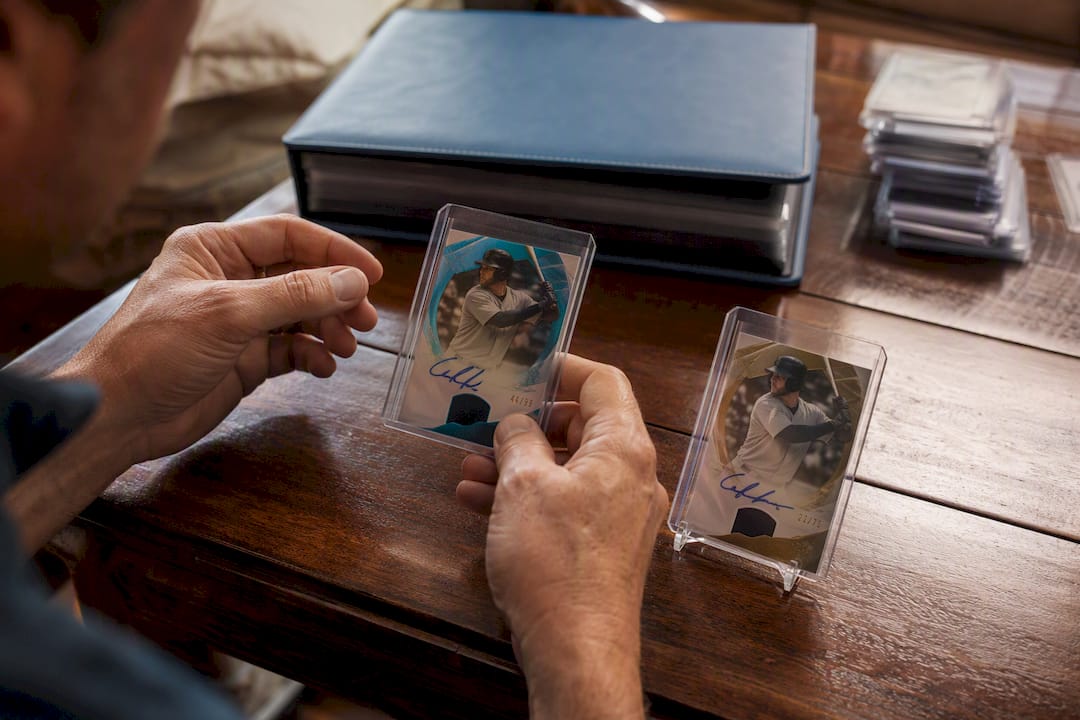 Collector hands holding numbered parallel autograph cards