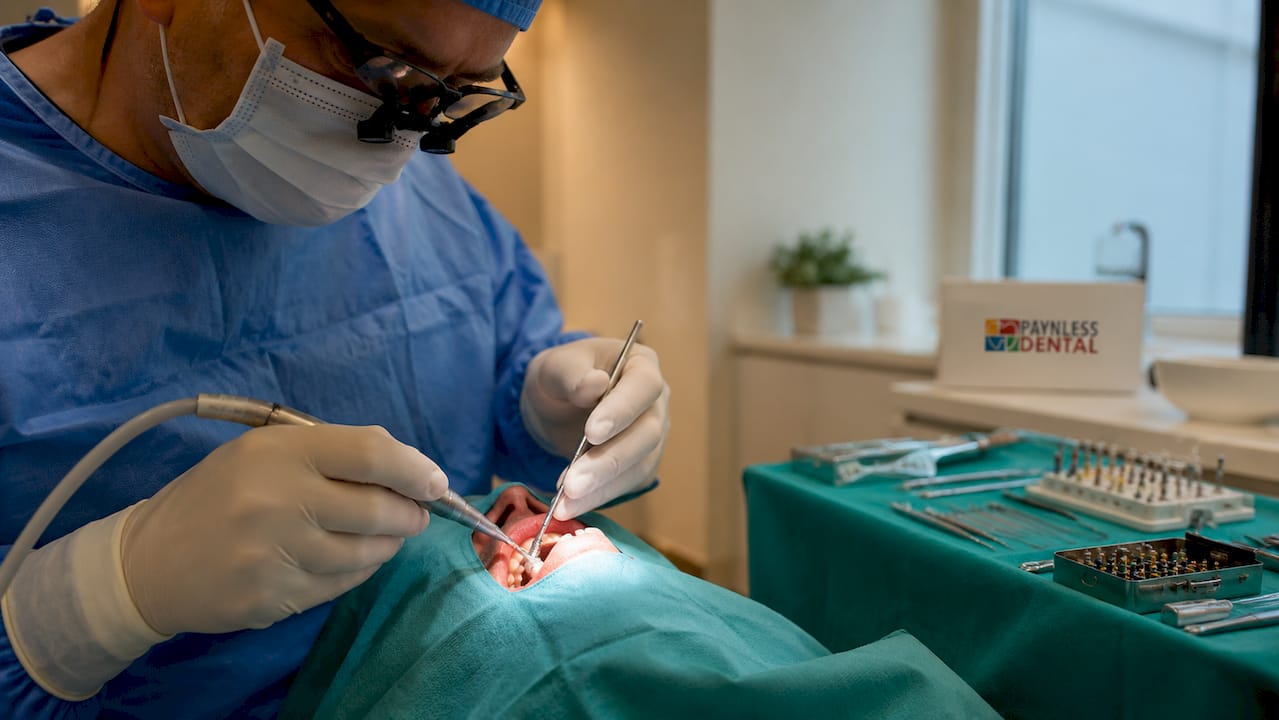 Close-up of dental implant surgery tools and hands
