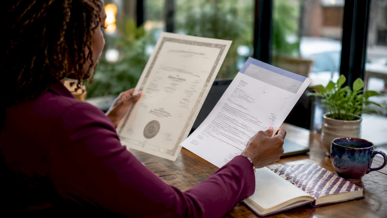 Hands comparing legal name documents