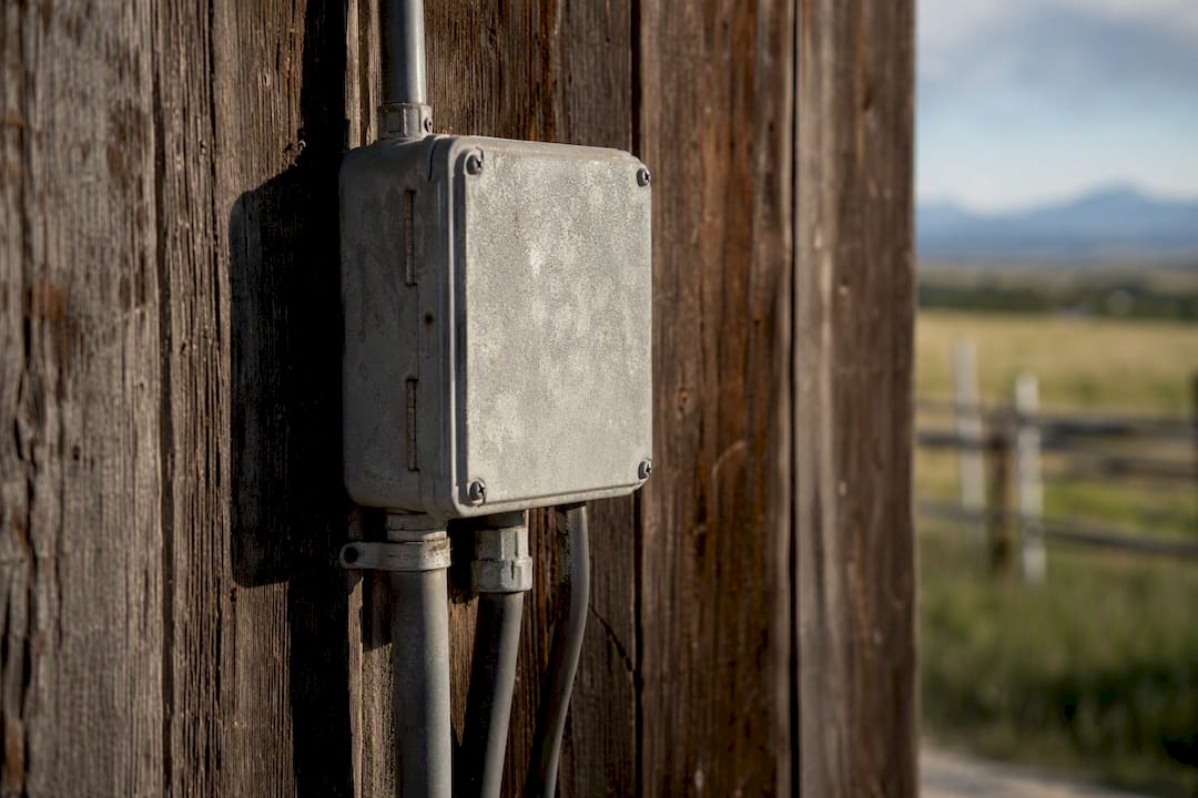 Sun-exposed weathered electrical box on barn exterior