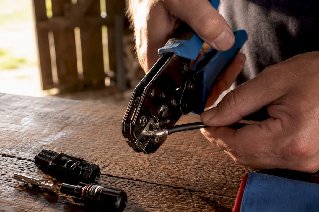 Hands crimping an MC4 solar connector