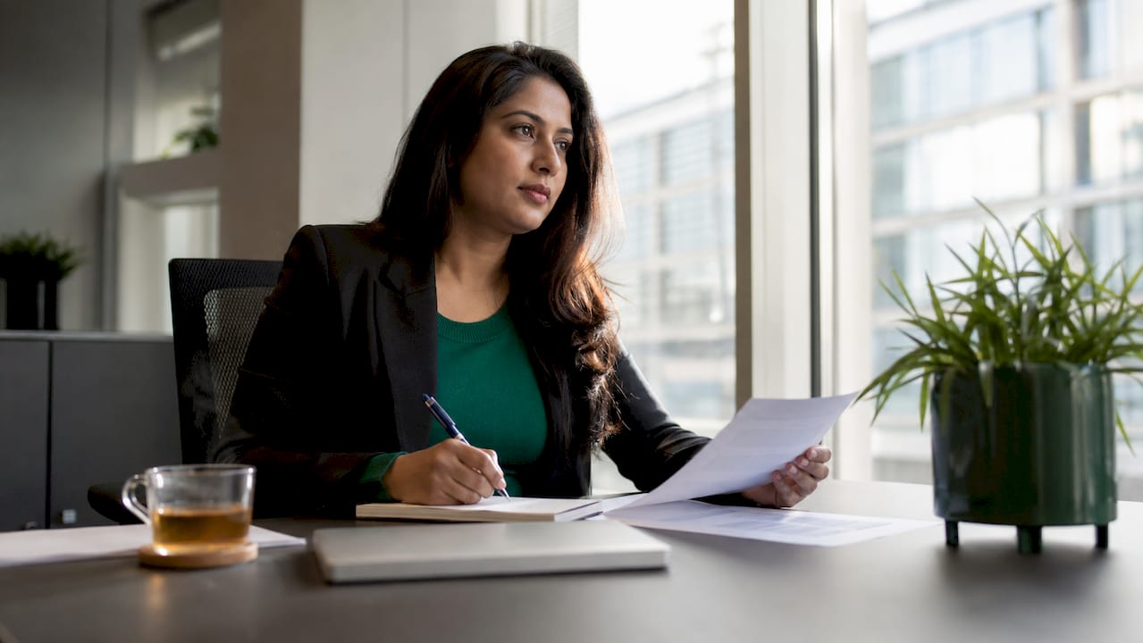 Woman reviewing crypto risk policy documents at office desk