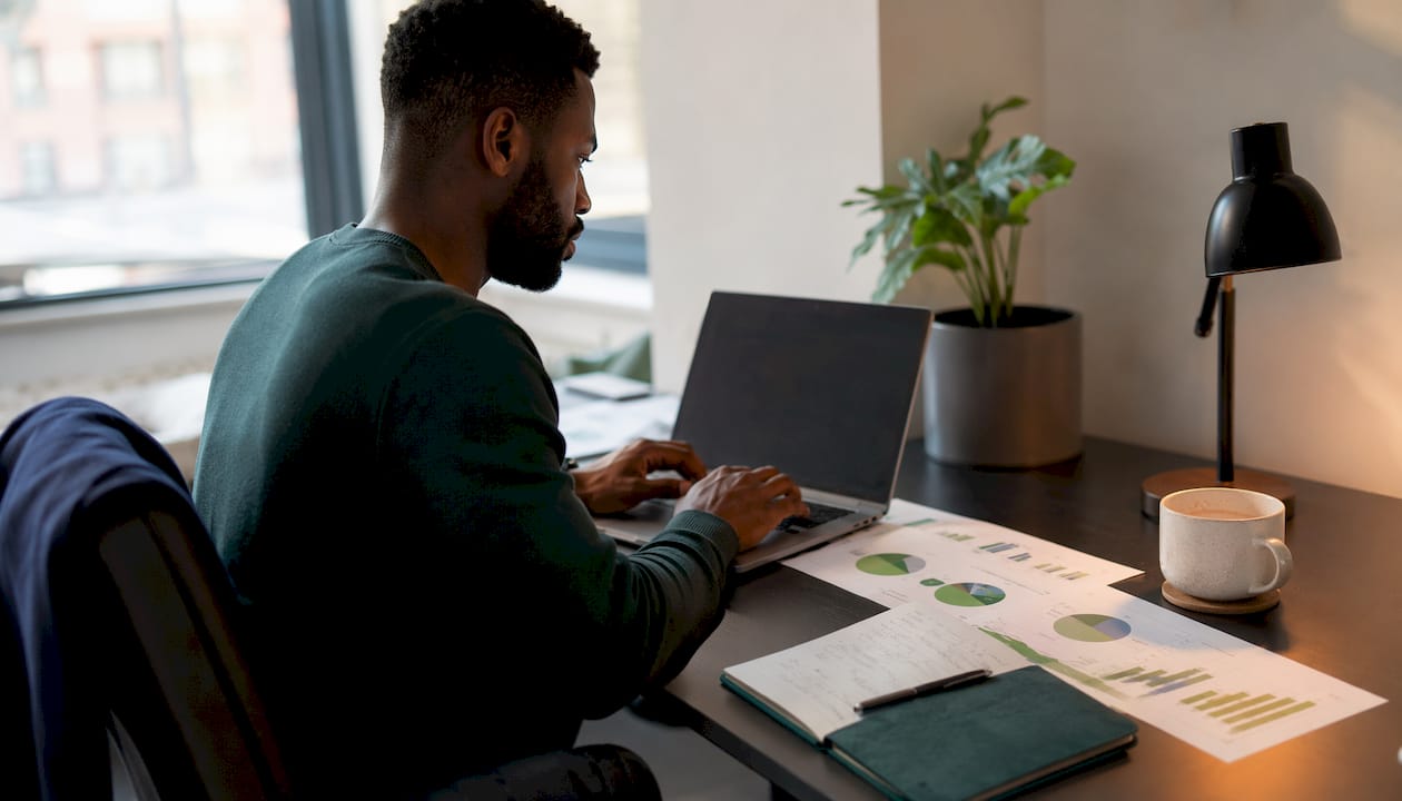 Hands typing at desk with ESG asset documents