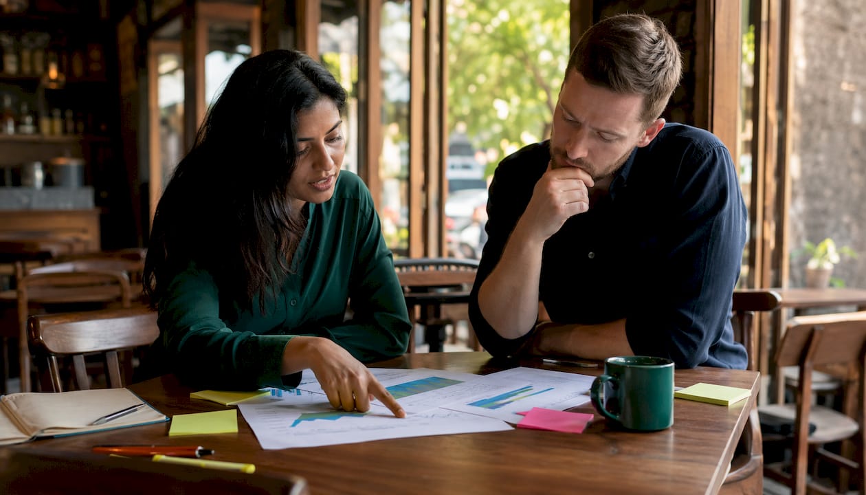 Two team members reviewing hedging instrument charts
