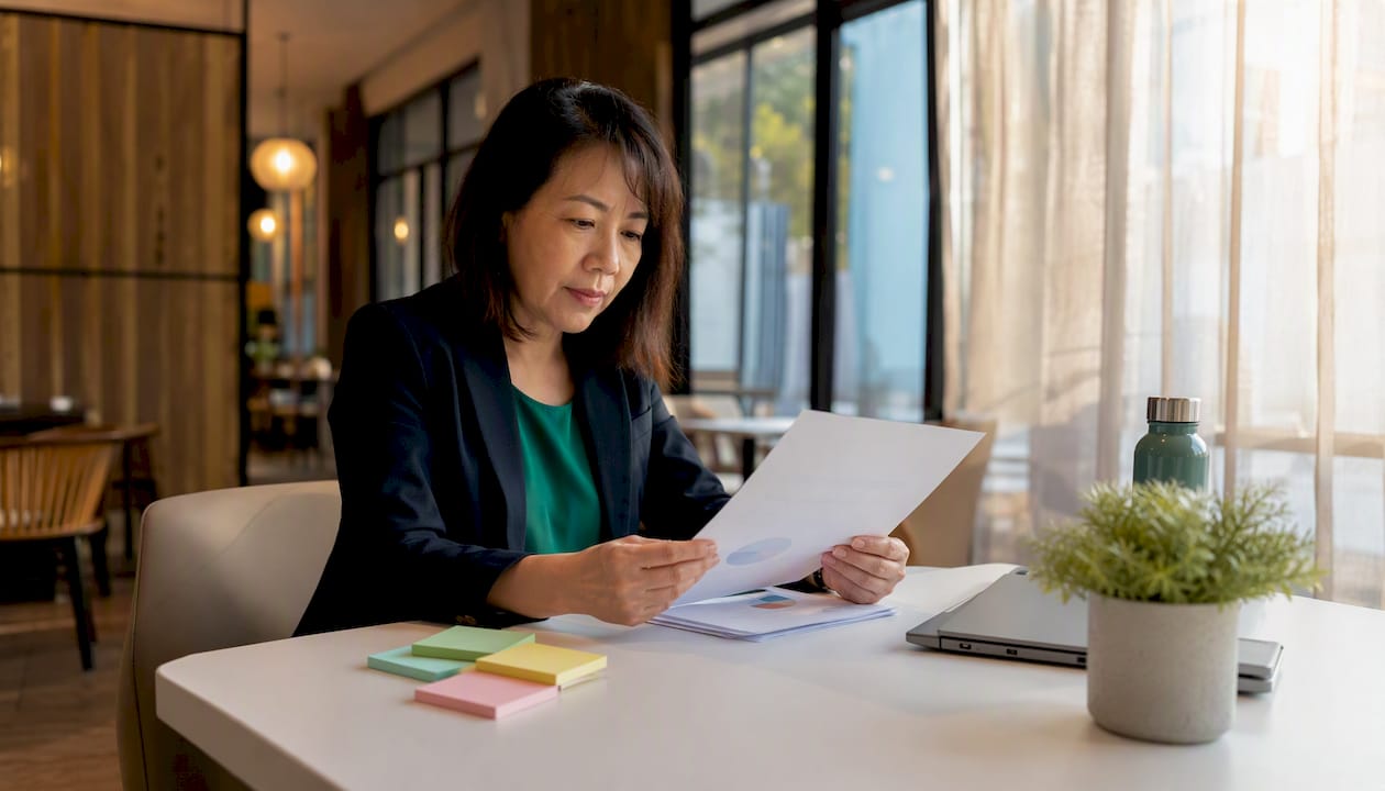 Businesswoman reviewing custody certification report at table