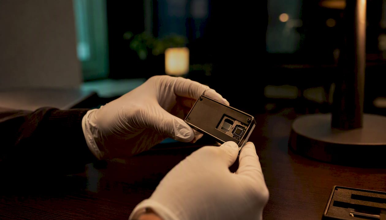 Gloved hands inspecting hardware custody device