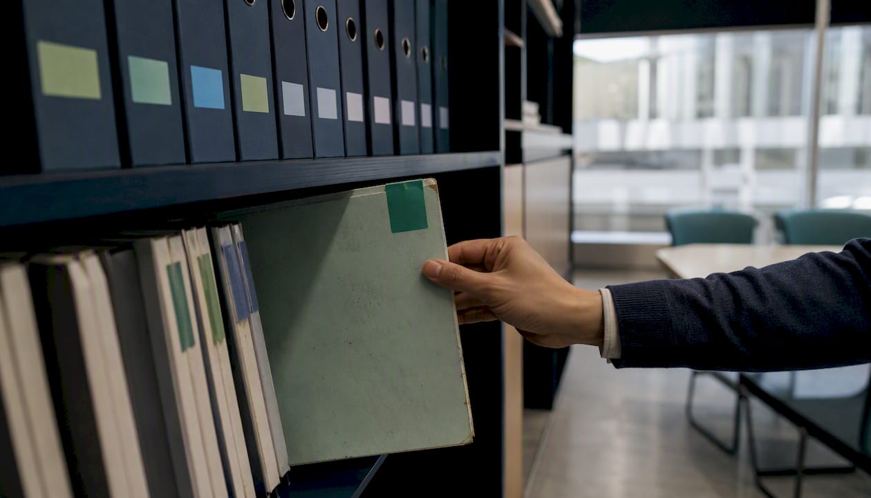 Hand placing compliance folder on shelf