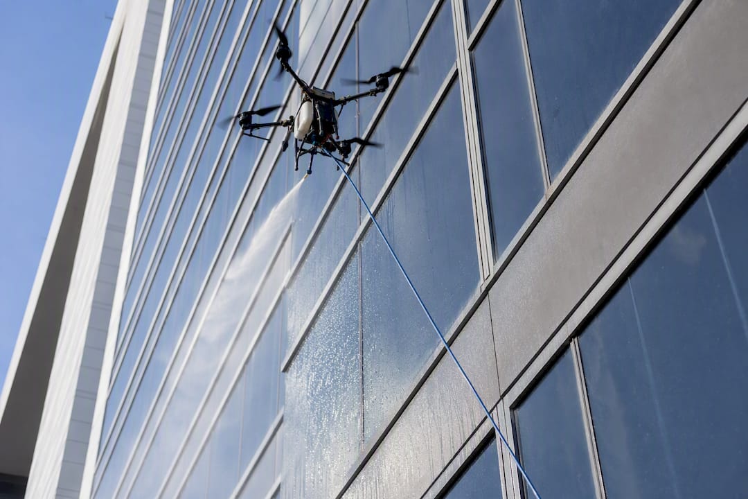 Tethered drone cleaning high-rise building facade