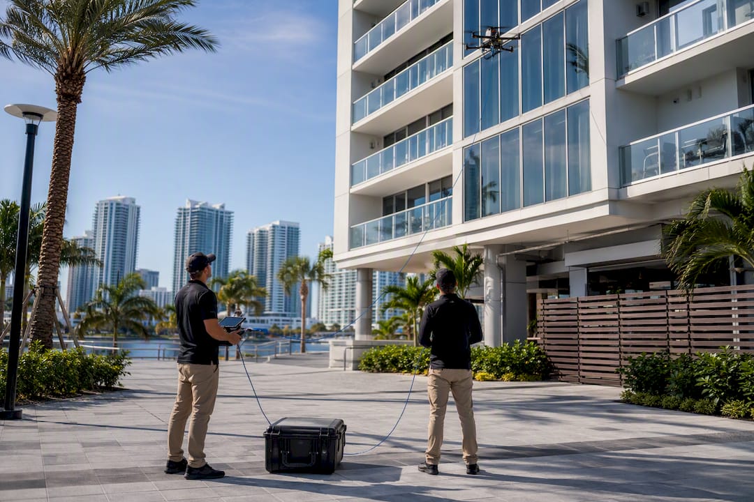 Ground crew monitoring high-rise cleaning drone