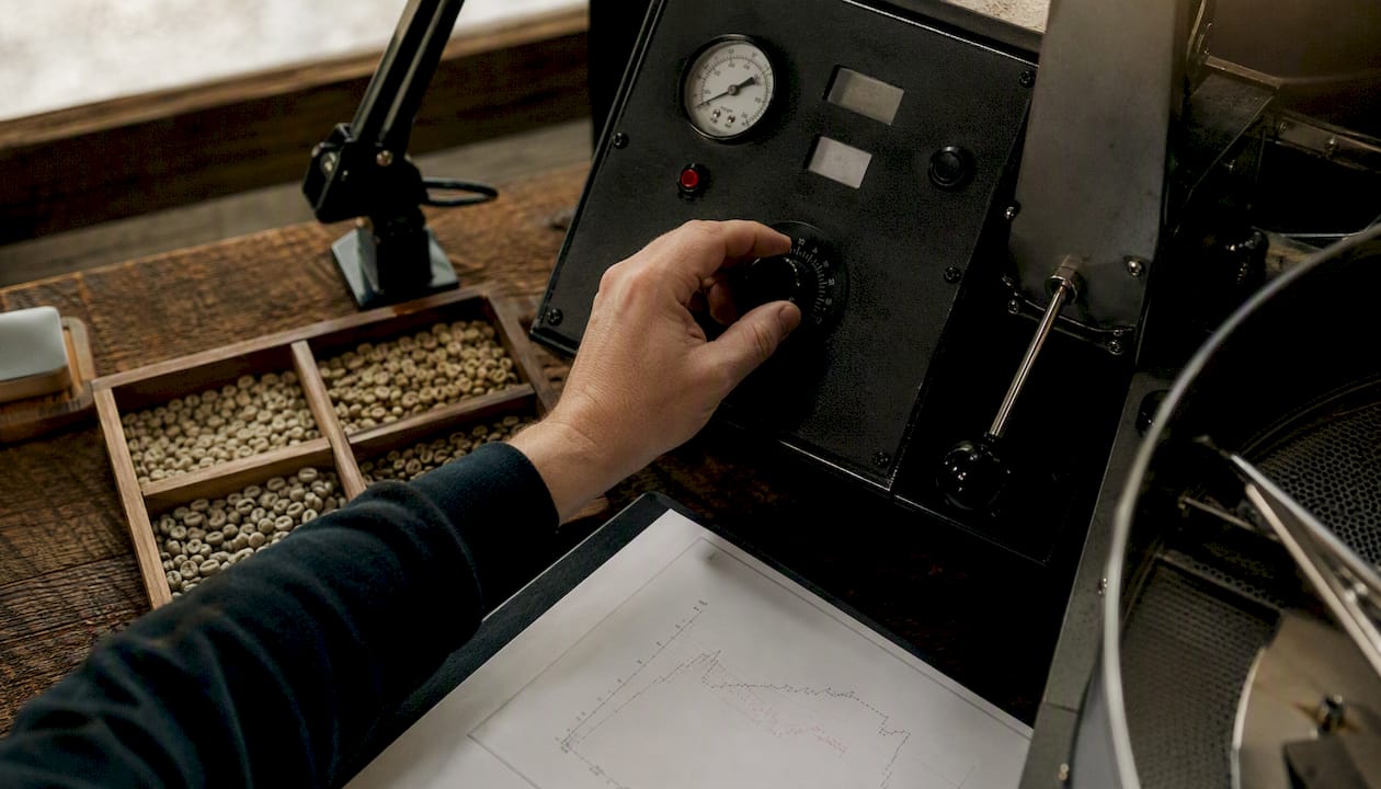 Hand adjusting small-batch roaster controls