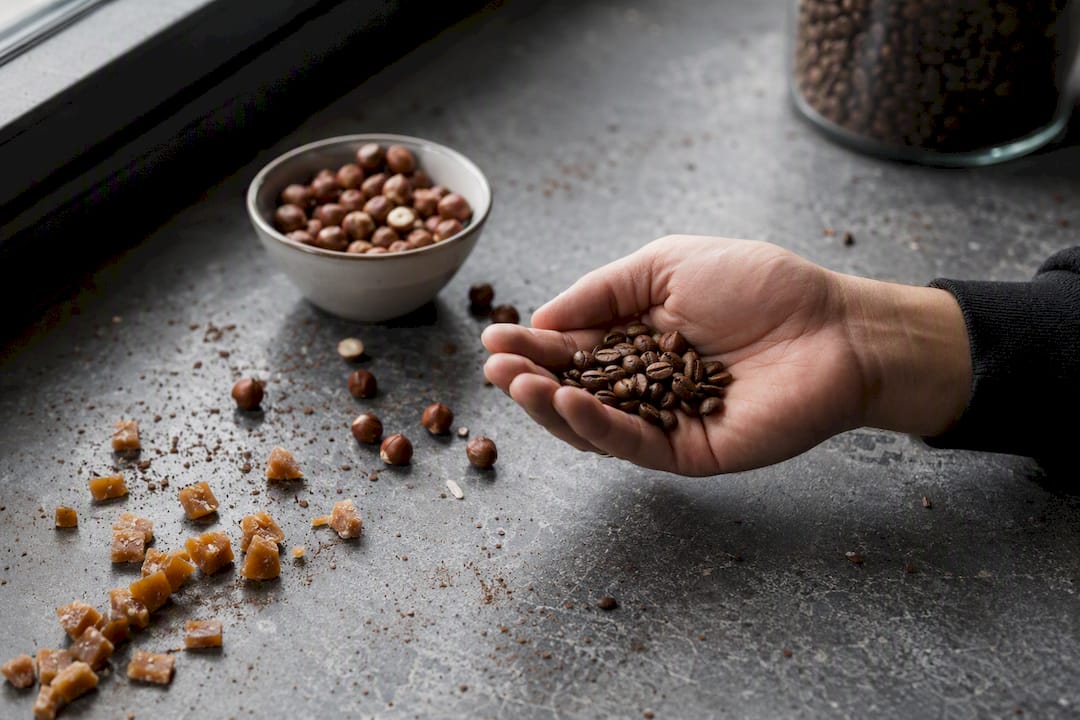 Hand holding medium roast coffee beans with flavor notes