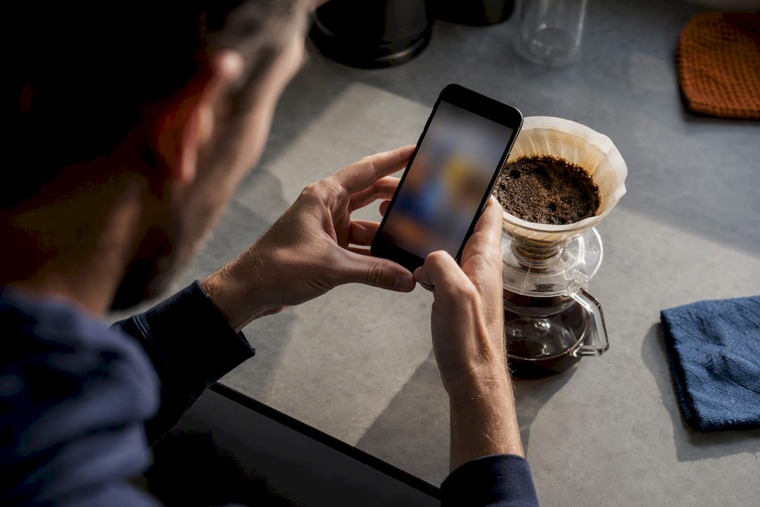 Barista photographing pour-over coffee bed