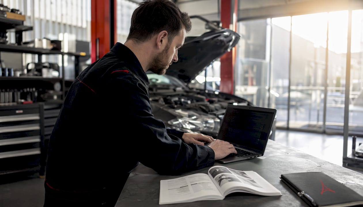 Un technicien ajuste les paramètres d’un moteur à l’aide d’un ordinateur portable.