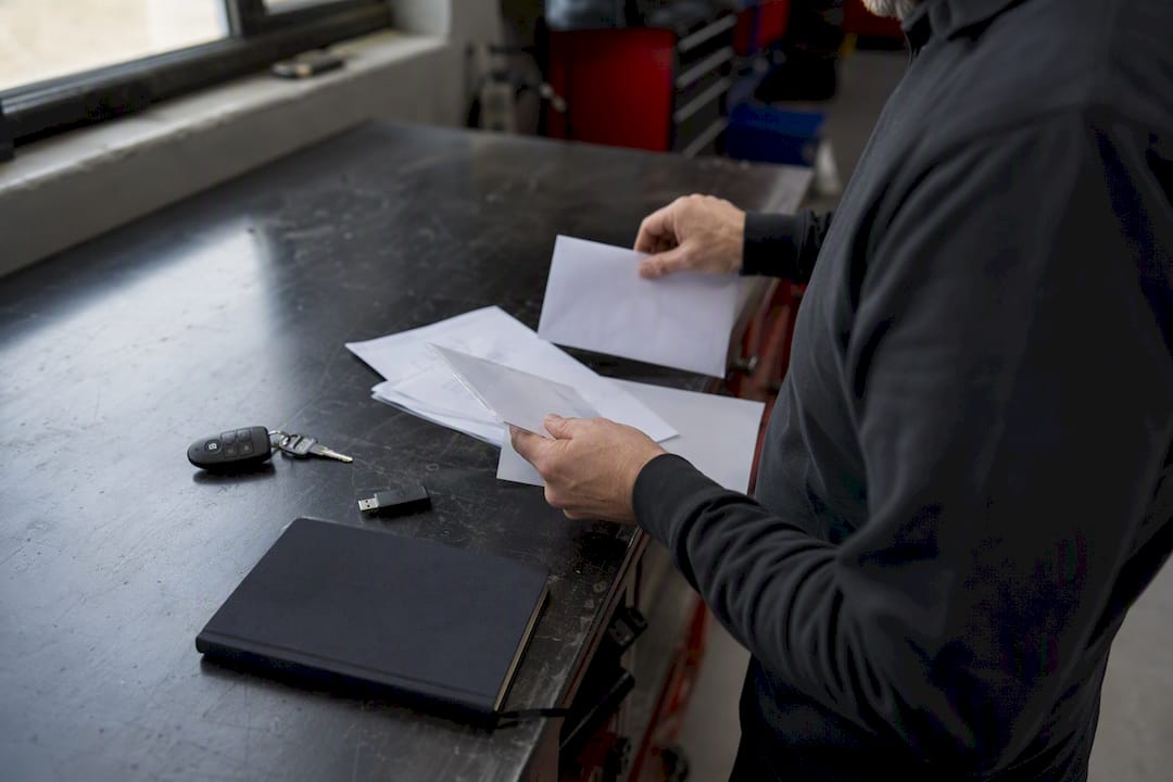 Des mains préparant des documents de déclaration sur un établi