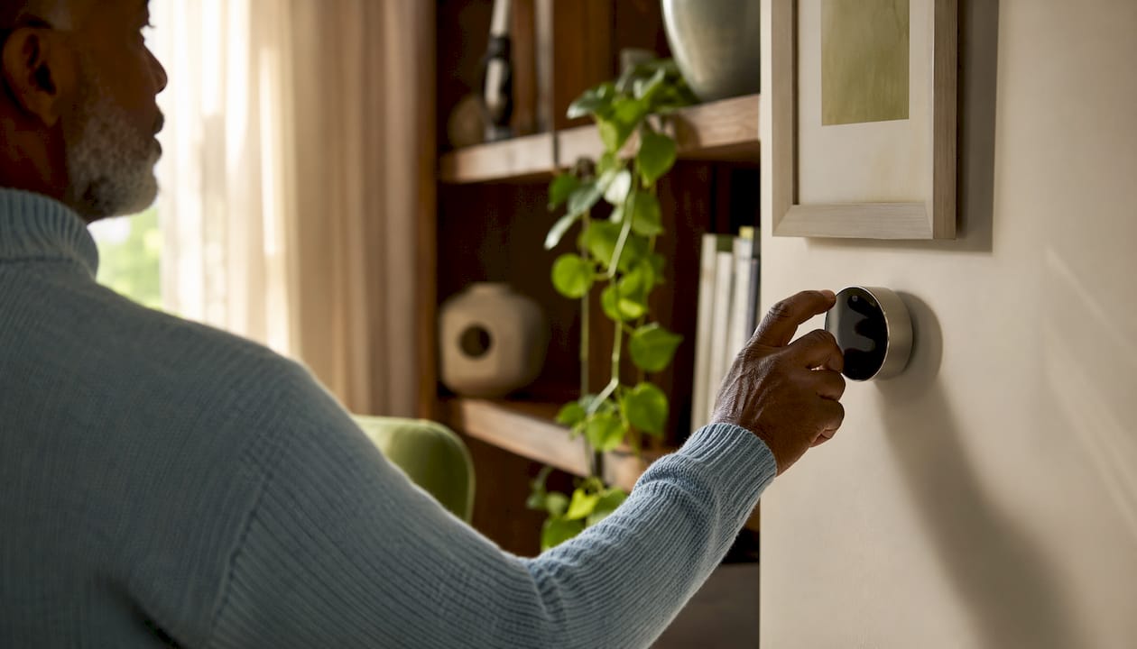 Hands adjusting home heating thermostat
