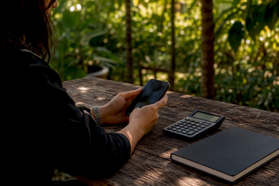 Hands calculating engagement rate with phone and calculator