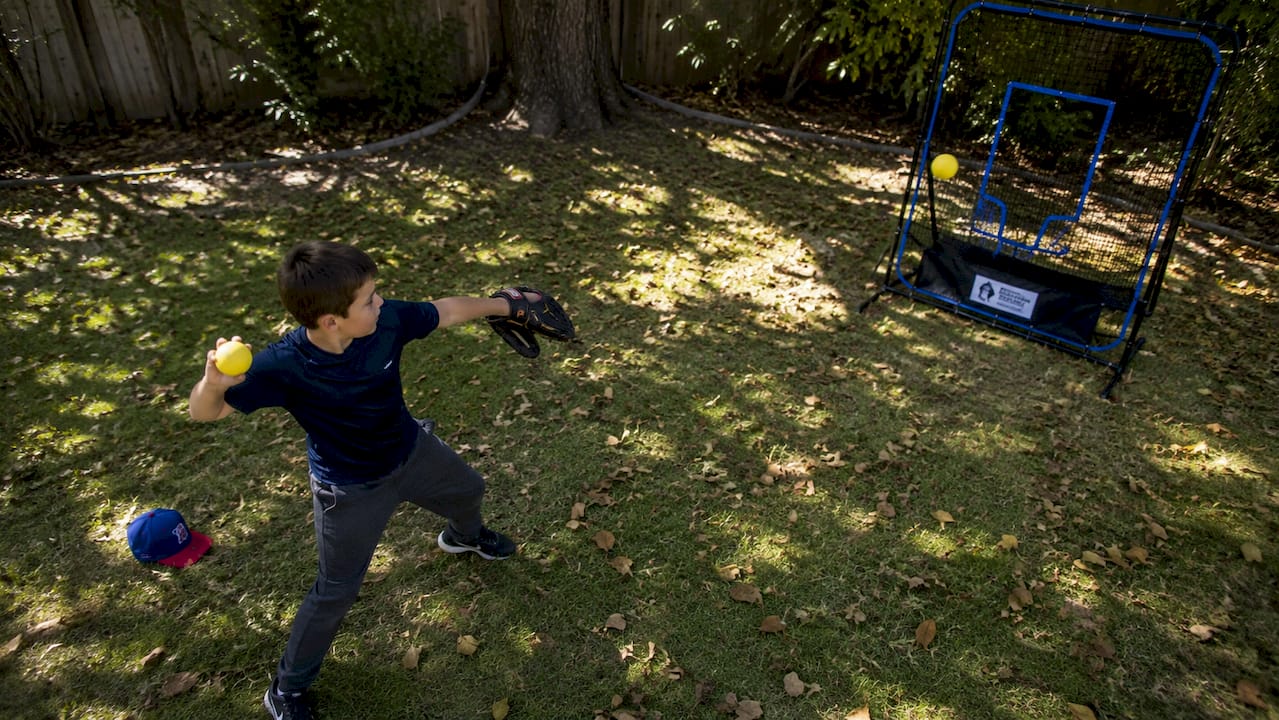 Youth baseball player practicing solo throw outdoors