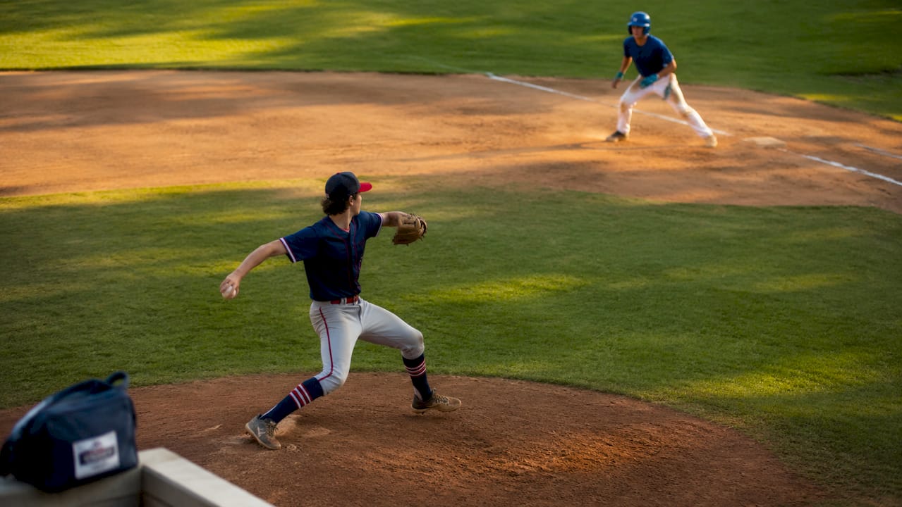 Side view of pitcher holding runner on base