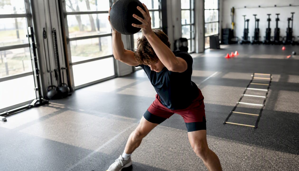 Youth athlete performing overhead medicine ball slam