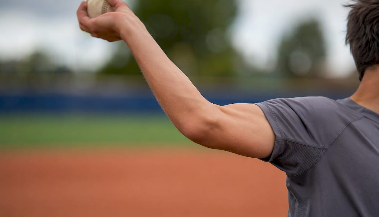 Close-up of youth pitcher's stressed elbow and shoulder