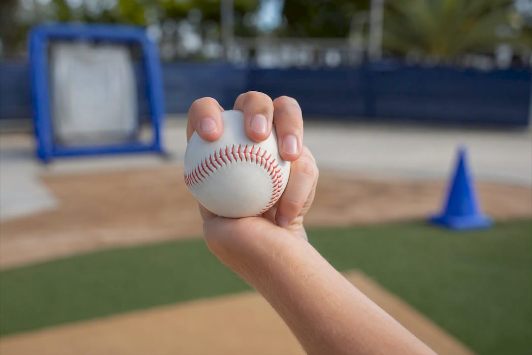 Close-up hand gripping baseball for curveball