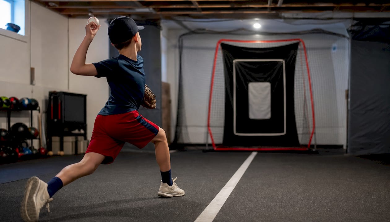 Pitcher performing stride-direction tape drill indoors