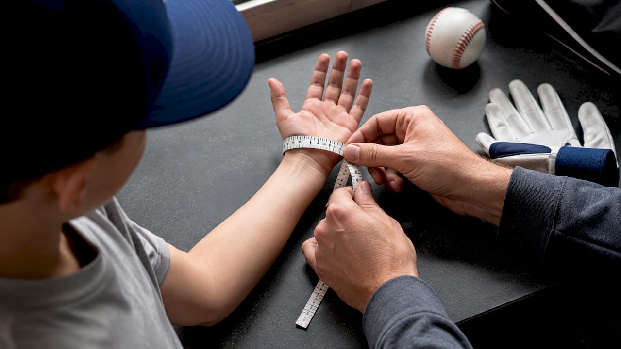 Parent measuring young player's hand circumference