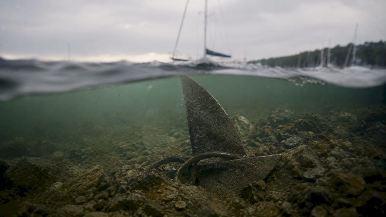Plow-style anchor digging into sandy seabed underwater