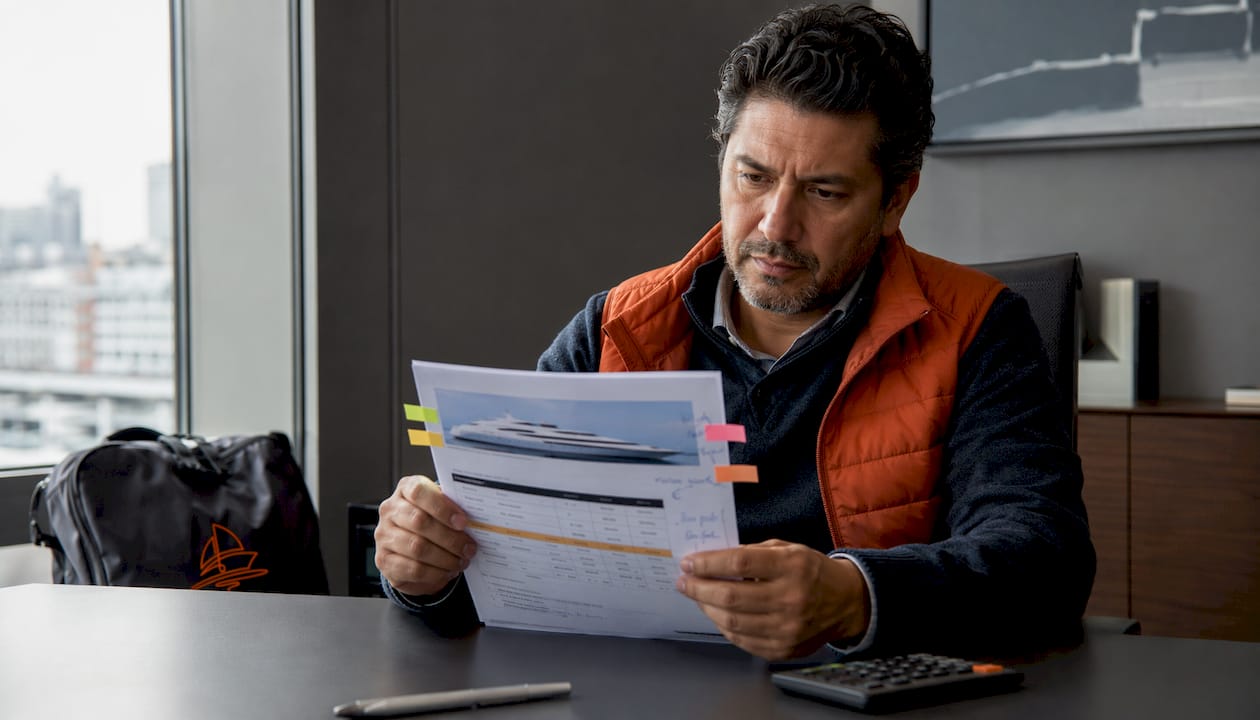Close-up of hands holding yacht payment schedule document