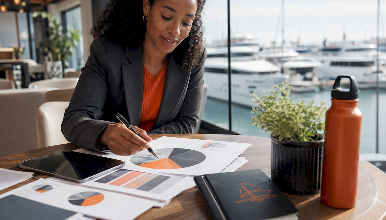 Woman explaining yacht charter cost chart in office