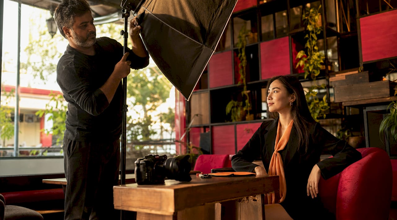 Photographer preparing female client for professional headshot