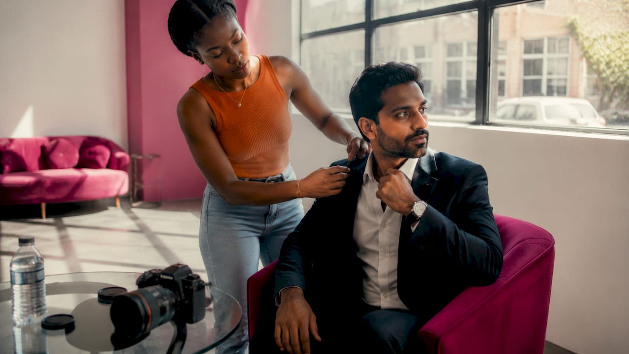 Photographer coaching male client on headshot pose
