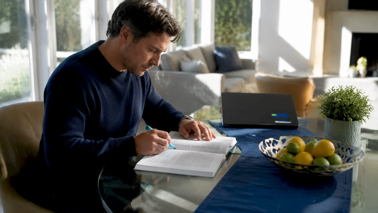 Hands holding insurance policy on desk overhead view