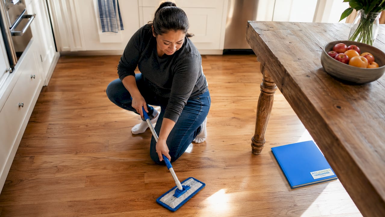 Woman dust mopping hardwood floor
