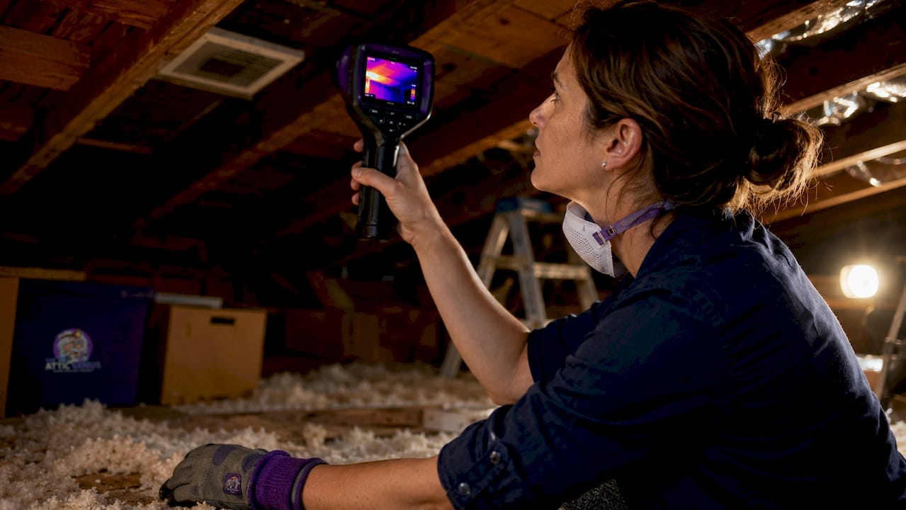 Auditor using thermal camera in attic